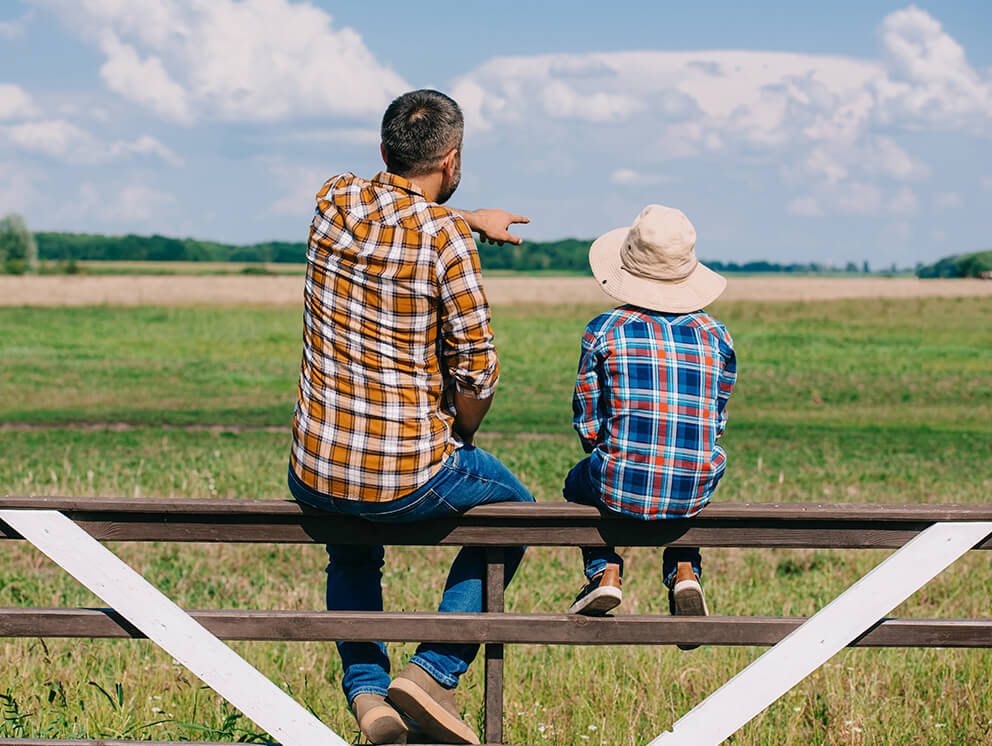 Father and son overlooking property.