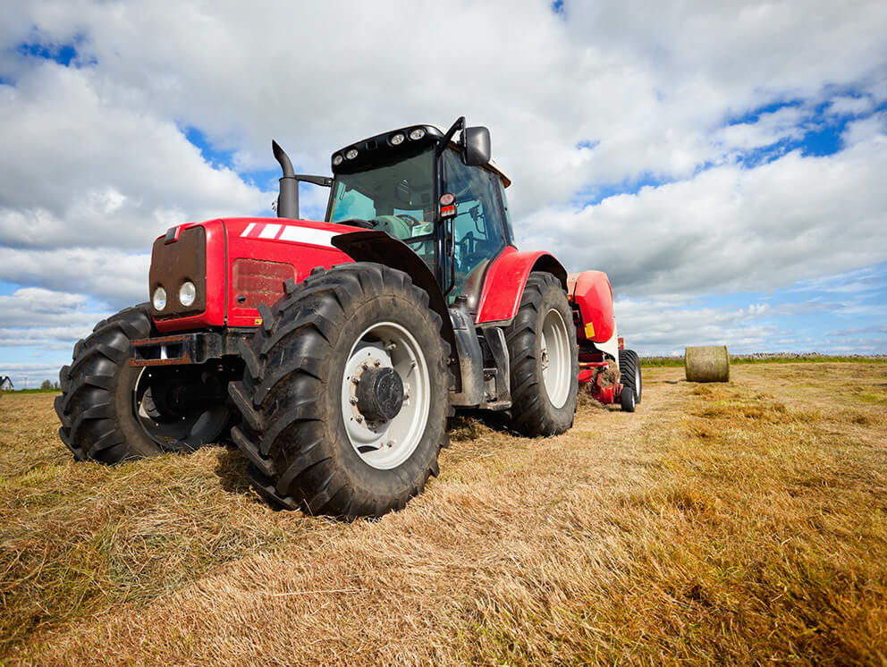 Big, red tractor with baler.